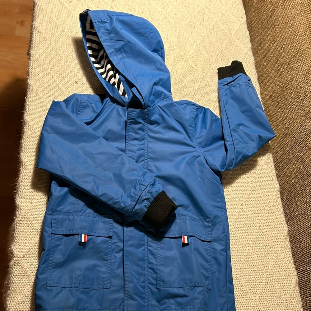 Boys blue raincoat with black/white striped liner. Great condition
